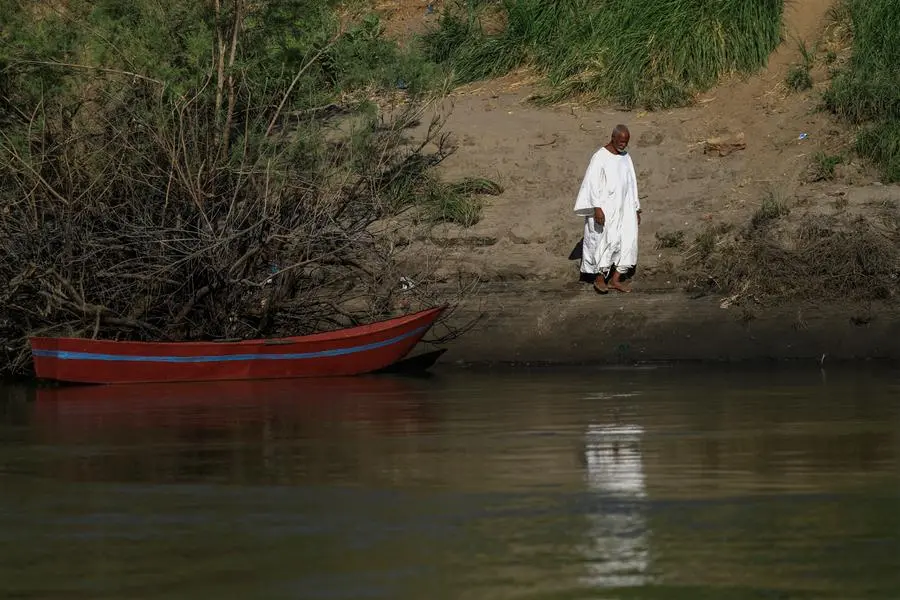 A man walks near a boat moored by the Nile river bank in Sudan's Northern State, near the Kassinger Islands, on October 28, 2022. - The Pharaohs worshipped it as a god, the eternal bringer of life, but the clock is ticking on the Nile. Climate change, pollution and exploitation by man is putting existential unsustainable pressure on the world's second longest river on which millions of Africans depend. (Photo by ASHRAF SHAZLY / AFP)