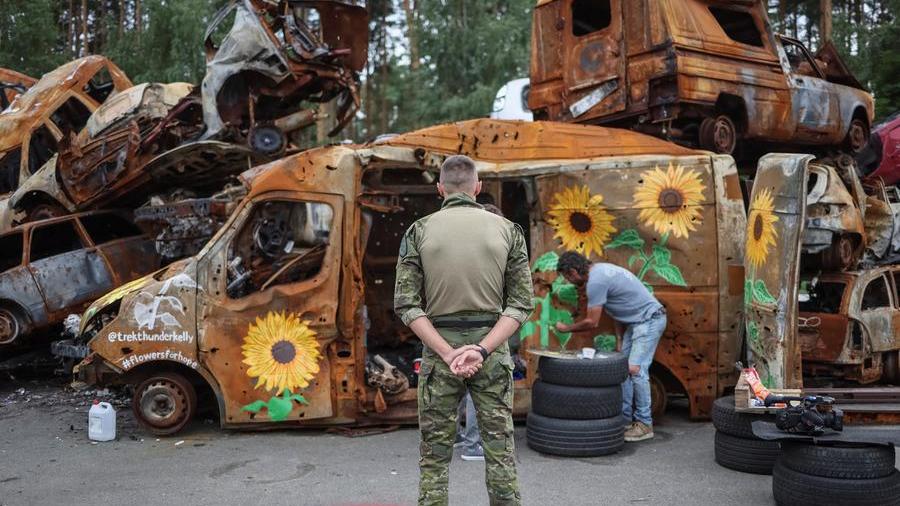 Artists paint sunflowers on Ukraine war wreckage