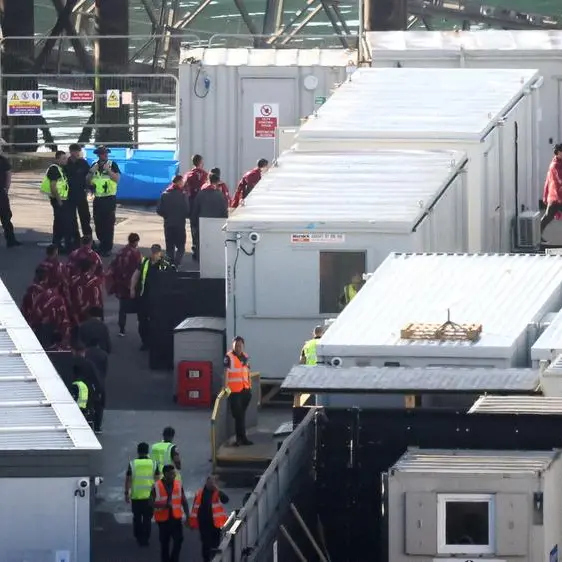 Migrants return to UK barge after contaminated water alert