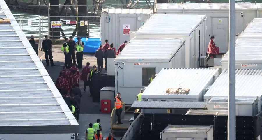 Migrants return to UK barge after contaminated water alert