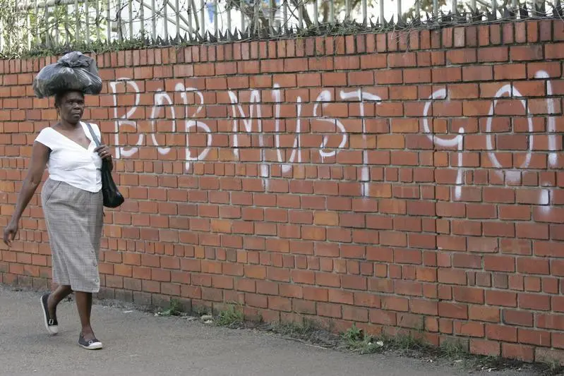 A woman walks past election graffiti in Harare, March 28, 2008. Zimbabwe goes to the polls in parliamentary and presidential elections on March 29. \"Bob\" refers to Zimbabwe\\'s President Robert Mugabe. REUTERS/Philimon Bulawayo (ZIMBABWE) - GM1E43T02HM01 , Reuters Images