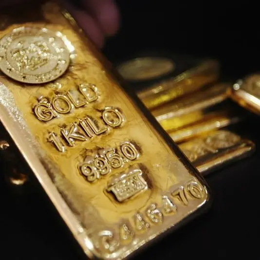 Gold edges lower as dollar gains on hawkish Fed minutes