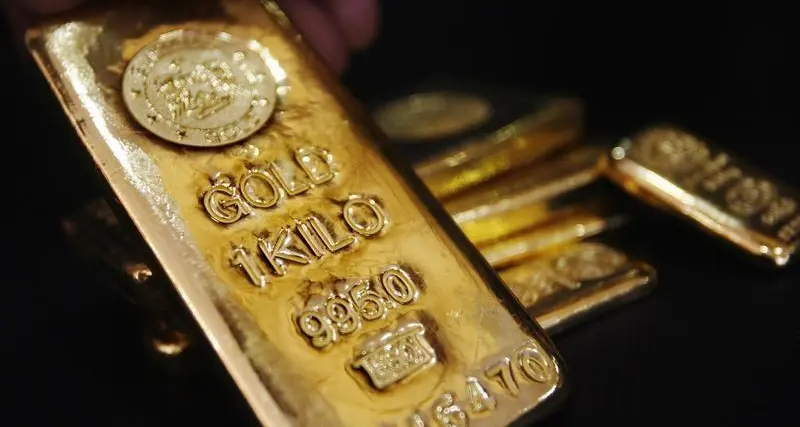 Gold edges lower as dollar gains on hawkish Fed minutes