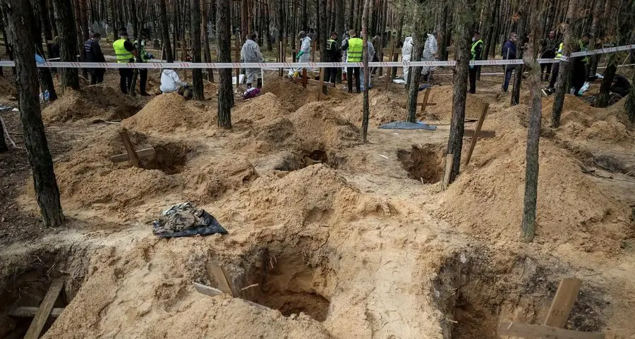 Ukrainians search grave site for relatives after Russians driven out