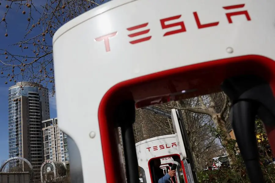 A driver holds a plug after charging his Tesla car at a Supercharger charging station of the electric vehicle (EV) maker in Beijing, China March 24, 2025. REUTERS/Florence Lo. , Reuters