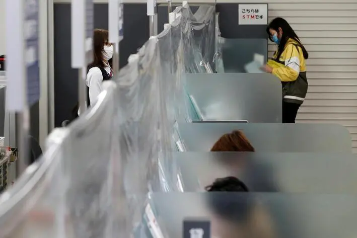 A bank teller wearing a protective face mask stands at a counter where a plastic curtain is installed in order to prevent infections following the coronavirus disease (COVID-19) outbreak, at the Higashinakano branch of MUFG Bank in Tokyo, Japan, April 24, 2020. REUTERS/Kim Kyung-Hoon , Reuters Images/REUTERS