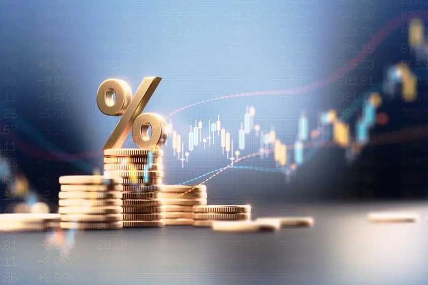 Percentage sign on top of coin stacks before blue financial graph. Horizontal composition with copy space. Business and finance concept. Image used for illustrative purpose. Getty Images , Getty Images