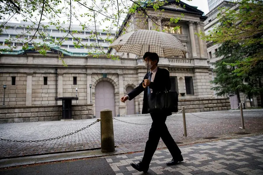 FILE PHOTO: An office employee walks in front of the bank of Japan building in Tokyo, Japan, April 7, 2023. REUTERS/Androniki Christodoulou. , Reuters