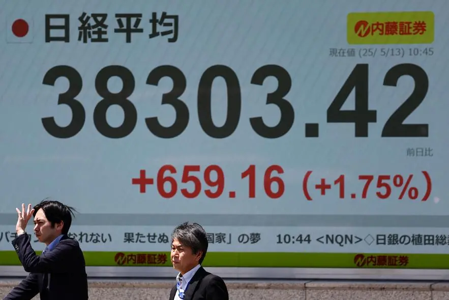 Pedestrians stand in front of a stock quotation board showing Nikkei share average outside a brokerage in Tokyo, Japan, May 13, 2025. REUTERS/Kim Kyung-Hoon. , Reuters