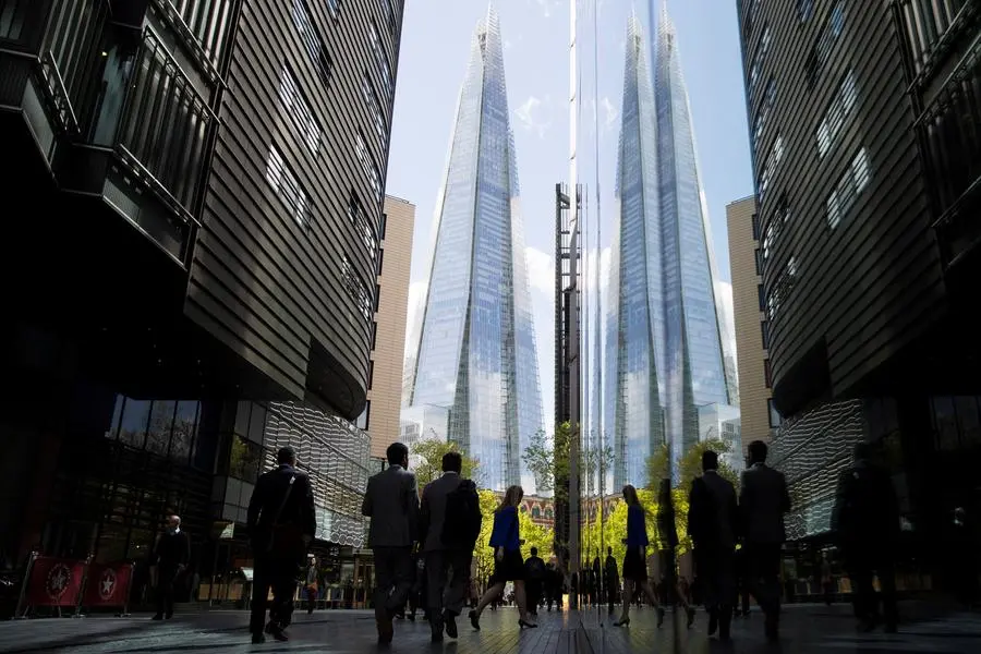 FILE PHOTO: City workers are reflected in a window as they pass near the Shard building in London, Britain April 28, 2015. REUTERS/Neil Hall. , Reuters