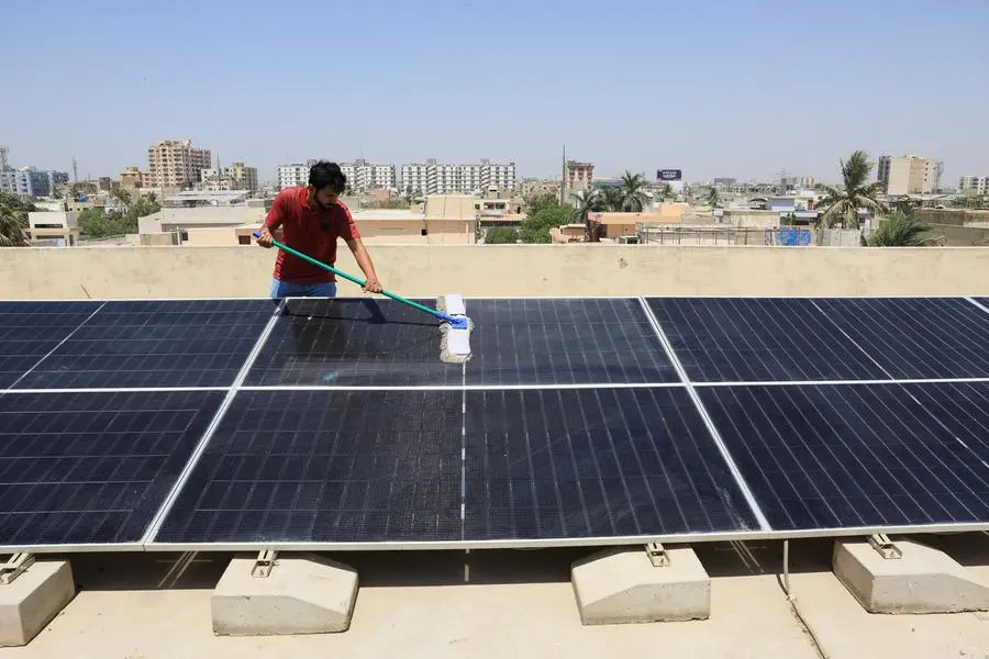 Syed Fahim Ali, 30, uses a wiper to clean the solar panels installed on the roof top of his home, in Karachi, Pakistan April 5, 2025. REUTERS/Akhtar Soomro. , Reuters