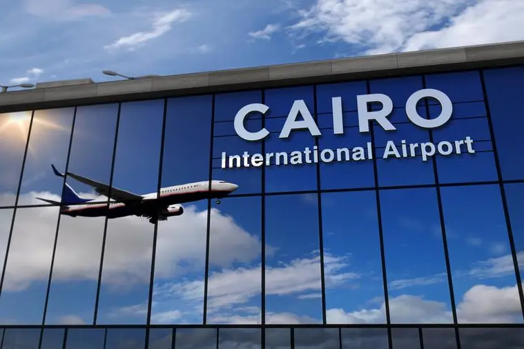 Jet aircraft landing at Cairo, Egypt 3D rendering illustration. Arrival in the city with the glass airport terminal and reflection of the plane. Travel, business, tourism and transport conce. Image used for illustrative purpose. Getty Images