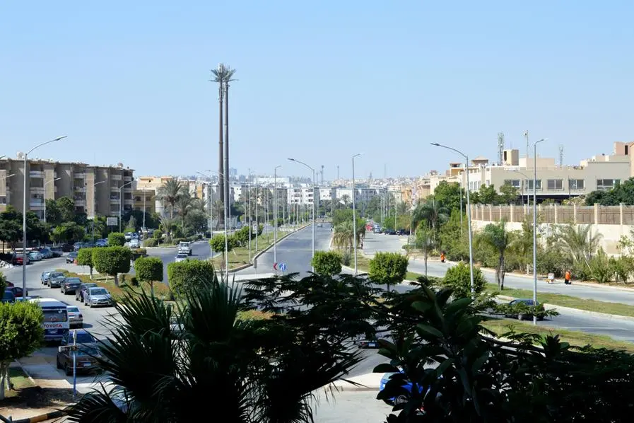 Giza, Egypt, August 19 2023: View of modern streets in Giza Sheikh Zayed city, cityscape background of Egyptian streets, traffic, trees, transmission tower, parking vehicles, people and buildings, selective focus. Image used for illustrative purpose. Image courtesy: Tamer Soliman/ Getty Images , Getty Images