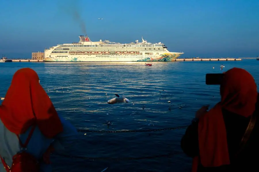 Women take pictures of a cruise ship docked in the Old Doha Port on December 26, 2024. (Photo by KARIM JAAFAR / AFP) , Agence France-Presse (AFP)/AFP