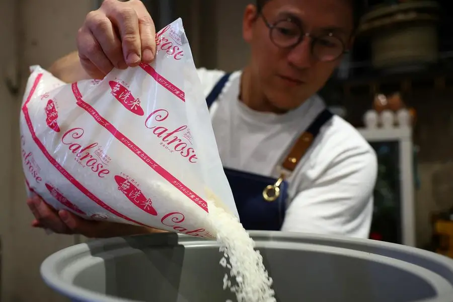 Arata Hirano, owner of the restaurant Shokudou Arata, pours California-grown Calrose rice into a rice cooker to cook rice at his restaurant in Tokyo, Japan, April 14, 2025. REUTERS/Kim Kyung-Hoon. , Reuters