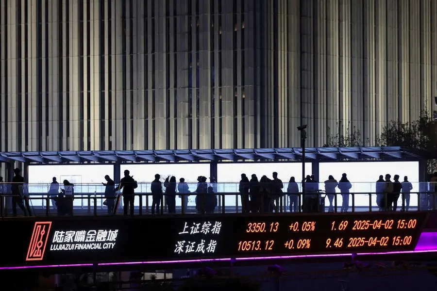 An electronic board shows Shanghai and Shenzhen stock indices as people walk on a pedestrian bridge at the Lujiazui financial district in Shanghai, China April 2, 2025. REUTERS/Go Nakamura. , Reuters