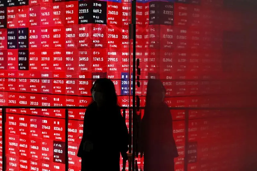 A woman walks in front of a stock quotation board inside a builidng in Tokyo, Japan April 25, 2025. REUTERS/Issei Kato. , Reuters