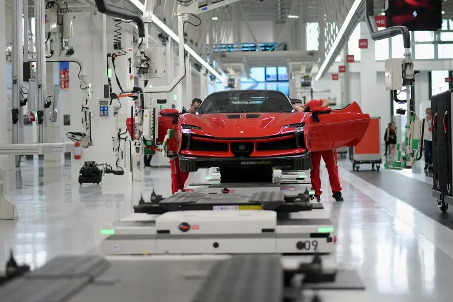 FILE PHOTO: Employees work at Ferrari\\'s new \\'e-building\\' facility, where the luxury sportscar maker is testing lines before an expected start of car production in early 2025, in Maranello, Italy, June 21, 2024. REUTERS/Daniele Mascolo. , Reuters