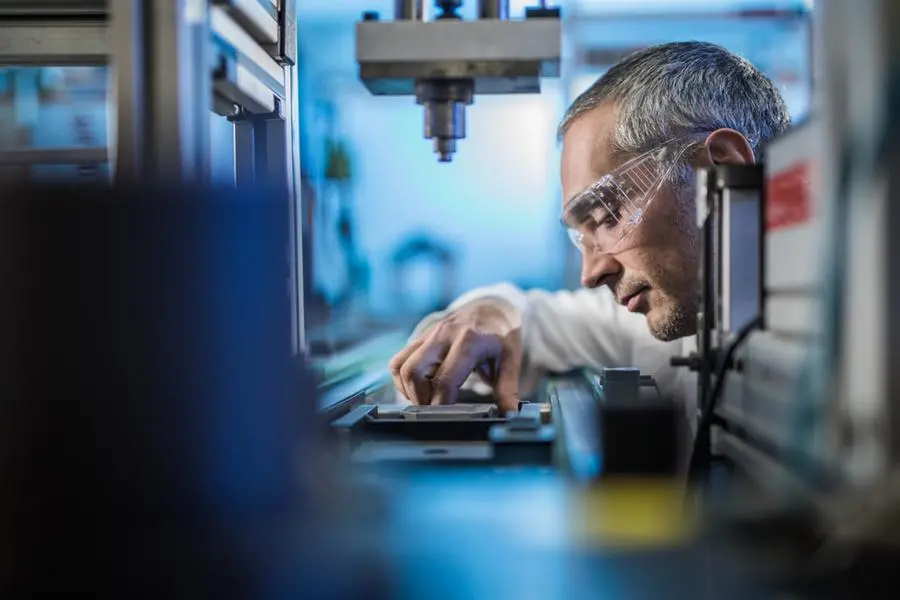 Mid adult male engineer examining machine part on a production line in a factory. Image used for illustrative purpose. Getty Images , Getty Images
