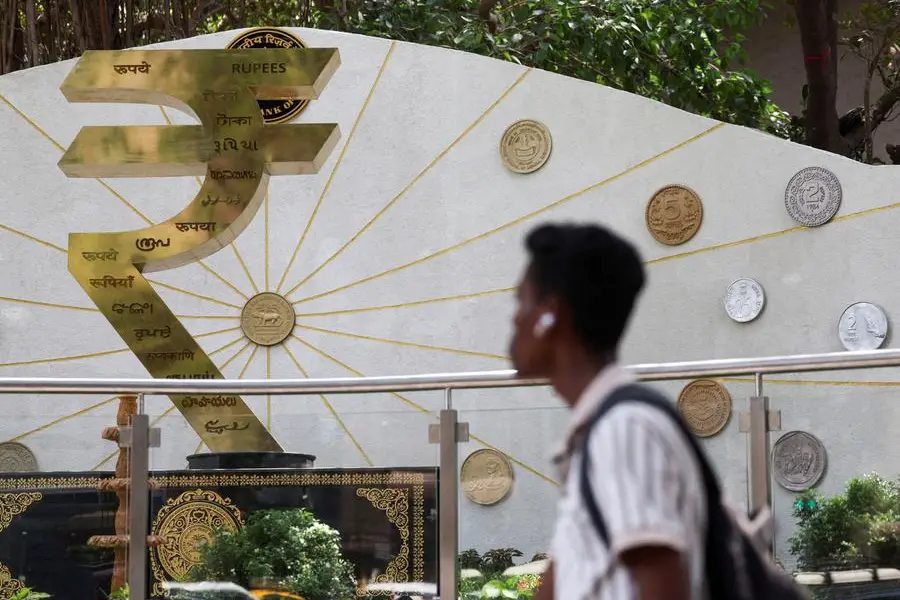 FILE PHOTO: A man walks past an installation of the Rupee logo and Indian currency coins outside the Reserve Bank of India (RBI) headquarters in Mumbai, India, April 9, 2025. REUTERS/Francis Mascarenhas. , Reuters