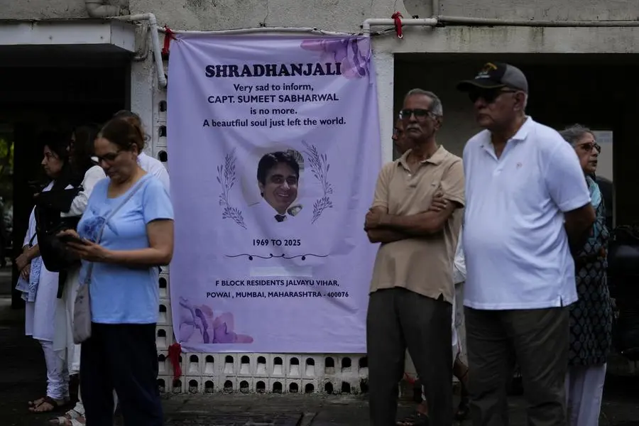 People stand next to a condolence banner as they wait for the body of Sumeet Sabharwal, a pilot who died when an Air India Boeing 787-8 Dreamliner crashed during take-off from an airport, to be handed over to his family in Mumbai, India, June 17, 2025. REUTERS/Hemanshi Kamani , Reuters/REUTERS