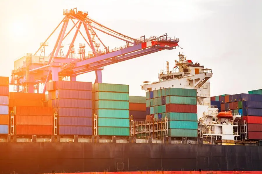 Container ship with working crane in commercial dock at sunset. Image used for illustrative purpose. Getty Images , Getty Images
