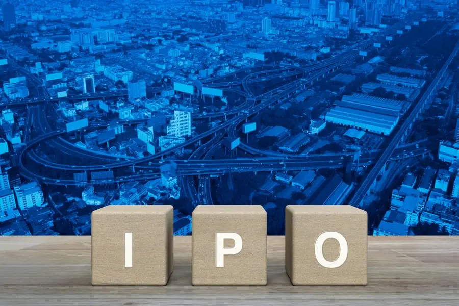 IPO letter on wood block cubes on wooden table over modern office city tower, street, expressway and skyscraper, Initial public offering concept. Image used for illustrative purpose. Getty Images