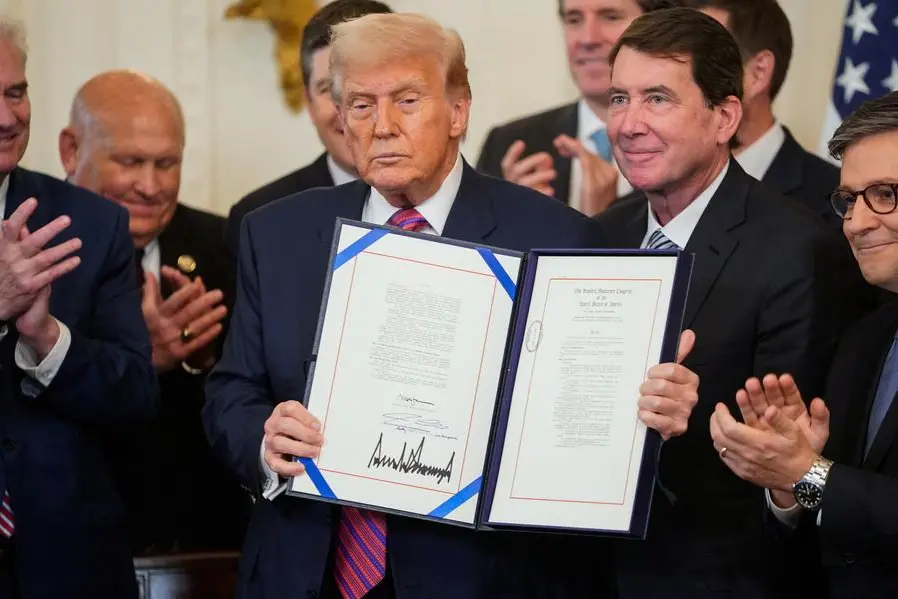 U.S. President Donald Trump holds the signed \"Genius Act\", which will develop regulatory framework for stablecoin cryptocurrencies and expand oversight of the industry, next to U.S. Senator Bill Hagerty (R-TN) and U.S. House Speaker Mike Johnson (R-LA), at the White House in Washington, D.C., U.S., July 18, 2025. REUTERS/Nathan Howard. , Reuters