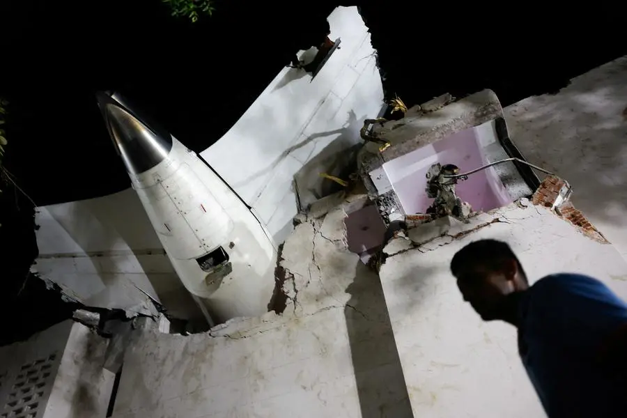 A person walks past debris at the crash site after an Air India aircraft, bound for London\\'s Gatwick Airport, crashed during take-off from an airport in Ahmedabad, India June 12, 2025. REUTERS/Adnan Abidi. , Reuters