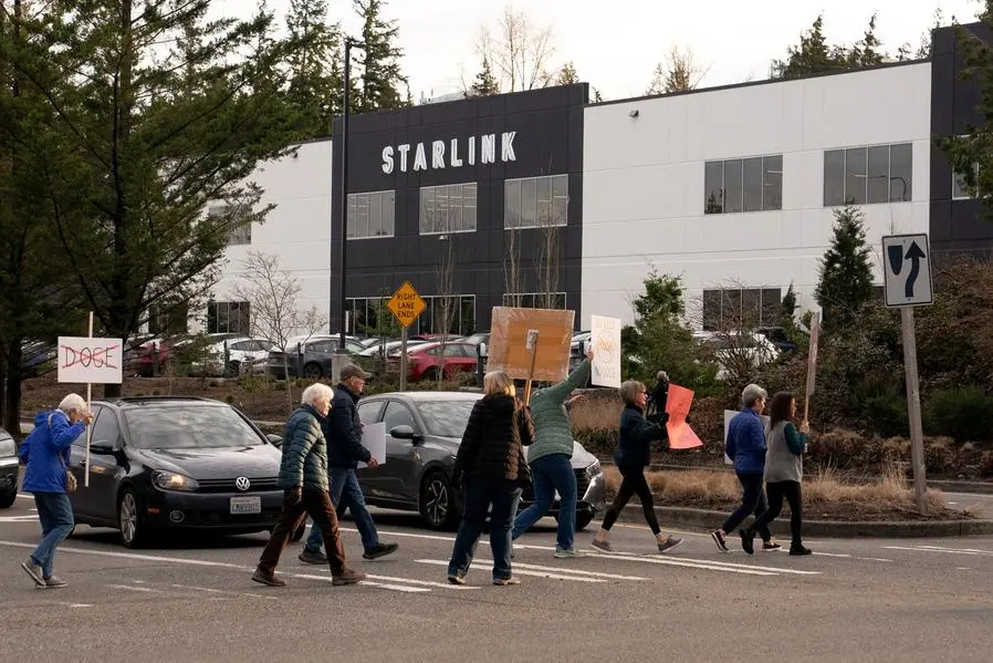 FILE PHOTO: Demonstrators cross the street during a protest outside SpaceX and Starlink facilities in Redmond, Washington, U.S., February 26, 2025. REUTERS/David Ryder. , Reuters