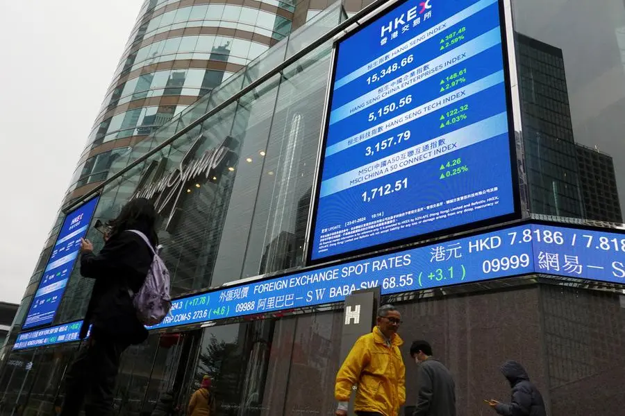 FILE PHOTO: People walk past screens displaying the Hang Seng stock index and stock prices outside the Exchange Square in Hong Kong, China January 23, 2024. REUTERS/Joyce Zhou. , Reuters