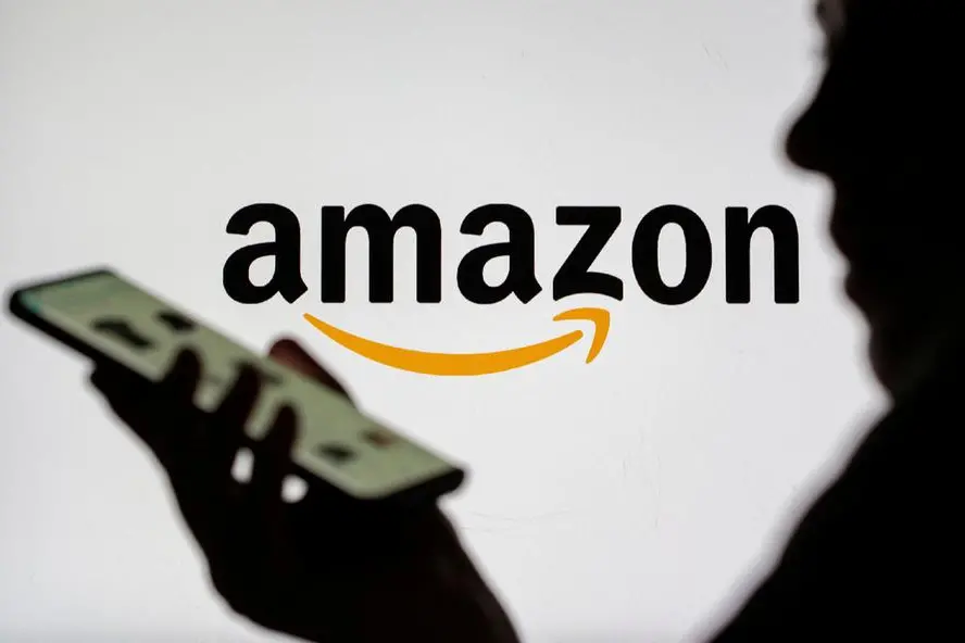 FILE PHOTO: Woman with smartphone is seen in front of displayed Amazon logo in this illustration taken, July 30, 2021. REUTERS/Dado Ruvic/Illustration. , Reuters