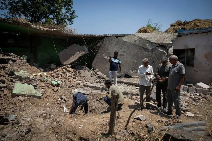 Villagers look for the fragments in a crater outside a house damaged by a cross-border shelling last week at Kot Maira, a border village in Jammu region, May 12, 2025. REUTERS/Adnan Abidi , Reuters/REUTERS