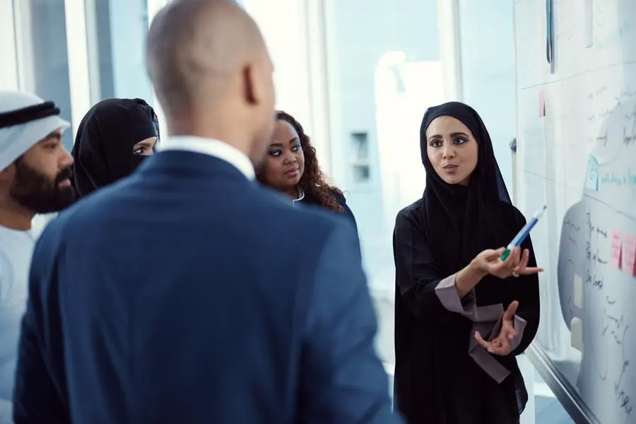Cropped shot of a group of diverse business colleagues working together on a whiteboard in their office. Image used for illustrative purpose. Getty Images