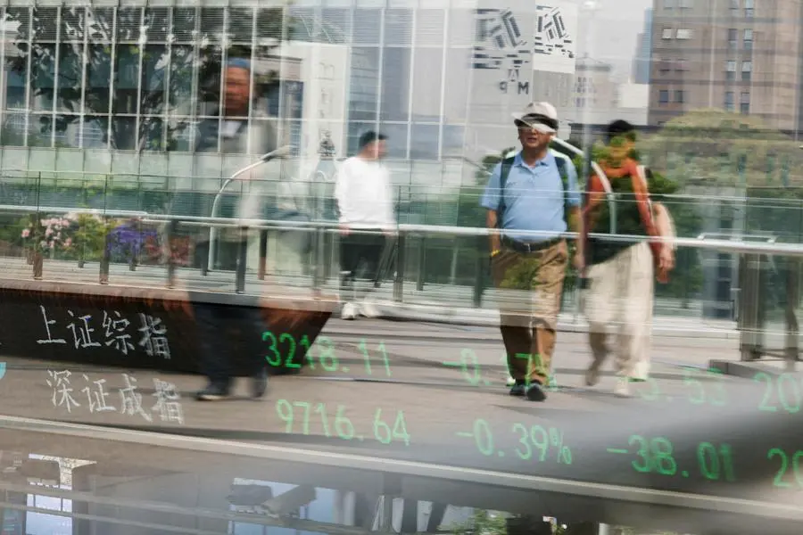 FILE PHOTO: An electronic board shows Shanghai and Shenzhen stock indices as people walk on a pedestrian bridge at the Lujiazui financial district in Shanghai, China April 11, 2025. REUTERS/Go Nakamura. , Reuters