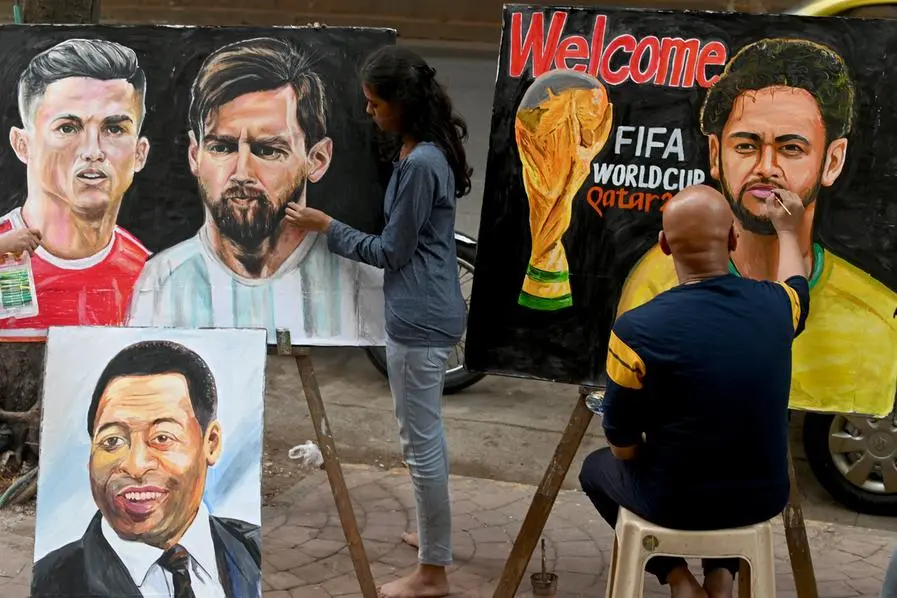 An art school student (L) gives final touches to painting of football players Portugal\\'s Christiano Ronaldo (top L) and Argentina\\'s Lionel Messi (top 2L) ahead of the Qatar 2022 World Cup football tournament in Mumbai on November 18, 2022. (Photo by INDRANIL MUKHERJEE / AFP) , AFP