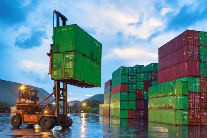 Crane lifting up container in warehouse Crane lifting containers for arrange in warehouse during sunset, this activity is to prepare container for import and export. Image used for illustrative purpose , Getty Images/ thianchai sitthikongsak