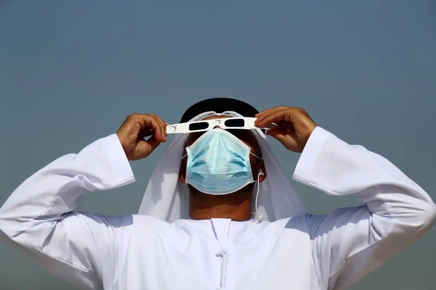 A man wears a face mask as he observes the partial solar eclipse through sunglasses at the Al Thuraya Astronomy Centre on June 21, 2020 in Dubai, United Arab Emirates. (Photo by Francois Nel/Getty Images)
