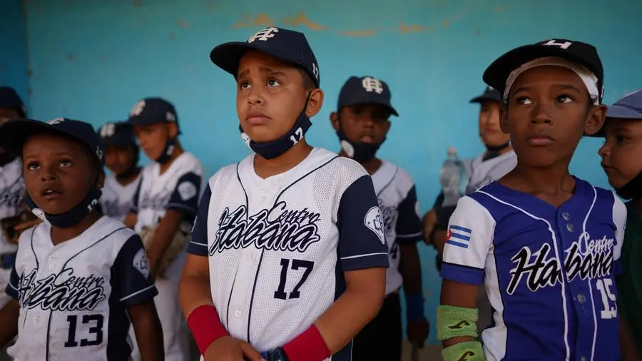 The Cuban baseball team listens to their national anthem at the