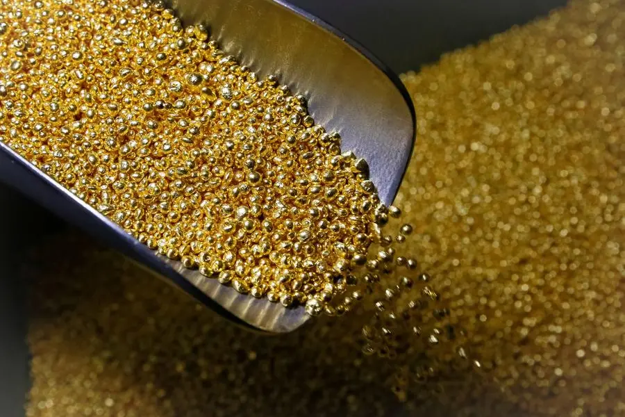 FILE PHOTO: An employee takes granules of 99.99 percent pure gold at the Krastsvetmet non-ferrous metals plant, one of the world\\'s largest producers in the precious metals industry, in the Siberian city of Krasnoyarsk, Russia November 22, 2018. Picture taken November 22, 2018. REUTERS/Ilya Naymushin. Image used for illustrative purpose , Reuters