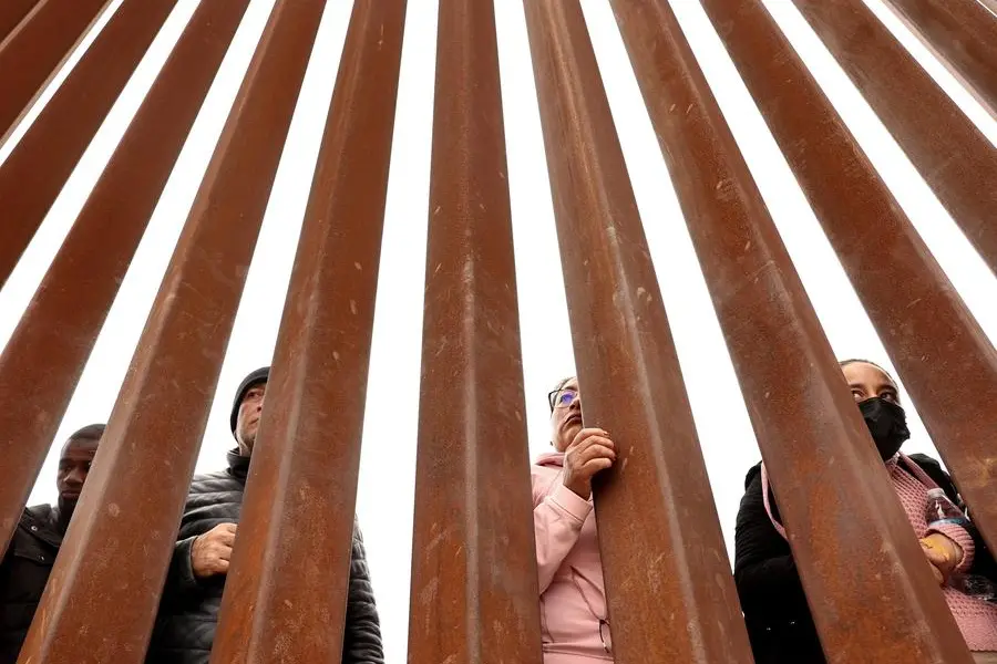 SAN DIEGO, CALIFORNIA - MAY 13: Immigrants seeking asylum in the U.S., who are stuck in a makeshift camp amongst the border walls between the U.S. and Mexico, look through the border wall on May 13, 2023 in San Diego, California. Some of the hundreds of migrants at the open-air camp have been waiting for days in limbo for a chance to plead for asylum, as local volunteer groups are providing food and other necessities. The U.S. government\\'s Covid-era Title 42 policy, which for the past three years had allowed for the quick expulsion of irregular migrants entering the country, expired in the evening on May 11th. Mario Tama/Getty Images/AFP (Photo by MARIO TAMA / GETTY IMAGES NORTH AMERICA / Getty Images via AFP) Image used for illustrative purpose.