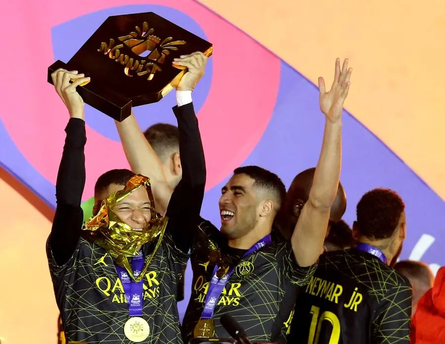 Soccer Football - Friendly - Saudi Pro League XI v Paris St Germain - King Fahd International Stadium, Riyadh, Saudia Arabia - January 19, 2023 Paris St Germain's Kylian Mbappe celebrates winning the match with a trophy and Achraf Hakimiin REUTERS/Ahmed Yosri