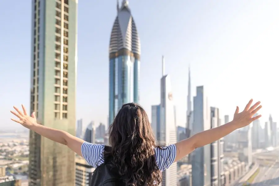 Tourists open their arms and look forward to the city of Dubai , Getty Images/Getty Images