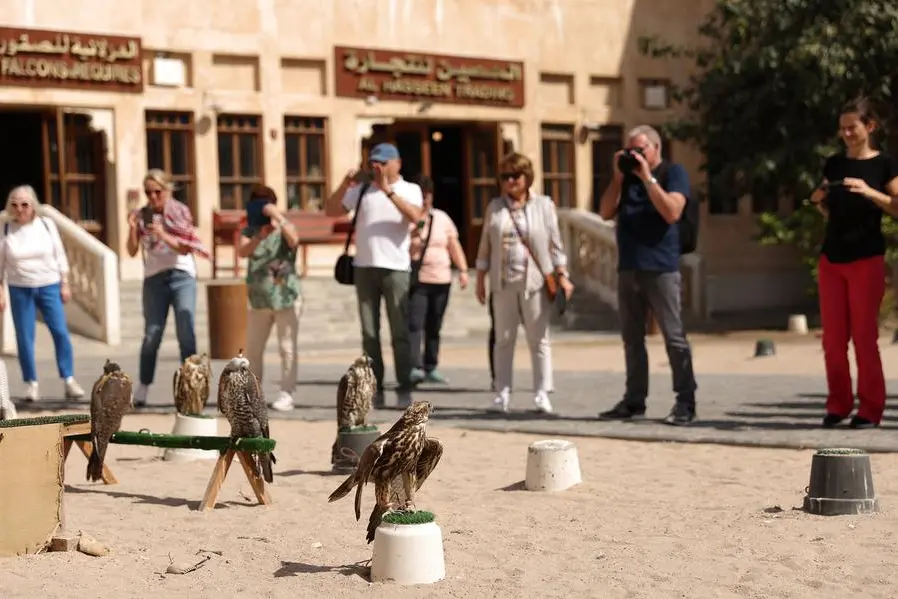 DOHA, QATAR - FEBRUARY 05: Tourists gather to see the falcons on display at the Falcon Souq on February 05, 2024 in Doha, Qatar. The falcon, a national symbol of Qatar, has been an integral part of the country\\'s culture for centuries. From the prized Saker to the Peregrine, these majestic birds are mostly imported from other Middle Eastern areas. They are not only used for hunting and competition but also hold a place of honor at the Falcon Souq, where falcon accessories and even a dedicated hospital to the birds can be found. (Photo by Robert Cianflone/Getty Images) , Getty Images
