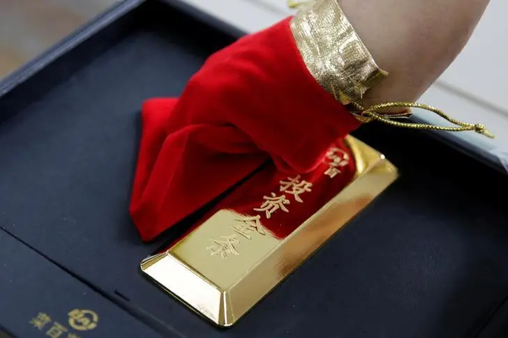 A sales assistant displays a 1000 gram gold bar as an investment for a customer at Caibai Jewelry store, in Beijing, China, August 6, 2019. Jason Lee, Reuters Image used for illustration , Reuters Images