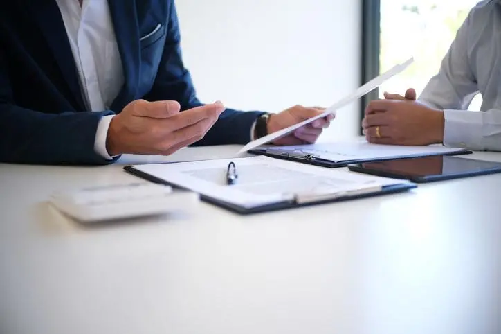 Image used for illustrative purpose. Cropped Image Of Insurance Agent Discussing With Client At Desk. Getty Images , Getty Images/EyeEm