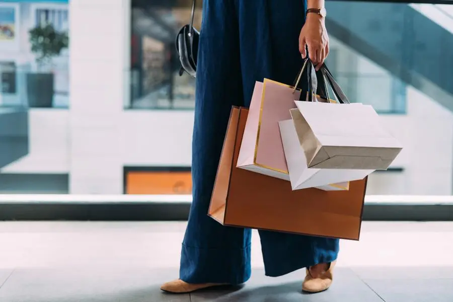 An unrecognizable Caucasian female standing at the shopping mall with paper bags. Image used for illustrative purpose. Getty Images , Getty Images