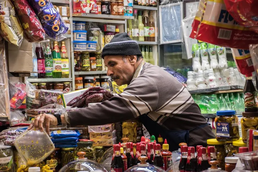 Arabic aged shopkeeper is the main subject focused who is from Iran arranging food items in his shop at souk mubarakiya, Kuwait market. Image used for illustrative purpose. Getty Images , Getty Images
