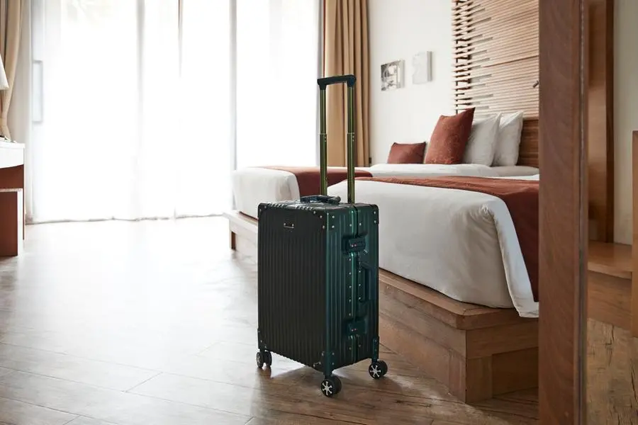 Suitcase by bed in hotel room at tourist resort. Getty Images Image used for illustrative purpose. , Getty Images