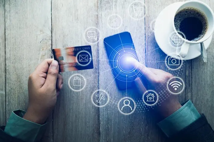 Image used for illustrative purpose. Person hands with credit card and mobile phone at desk, Online shopping concept. , Getty Images